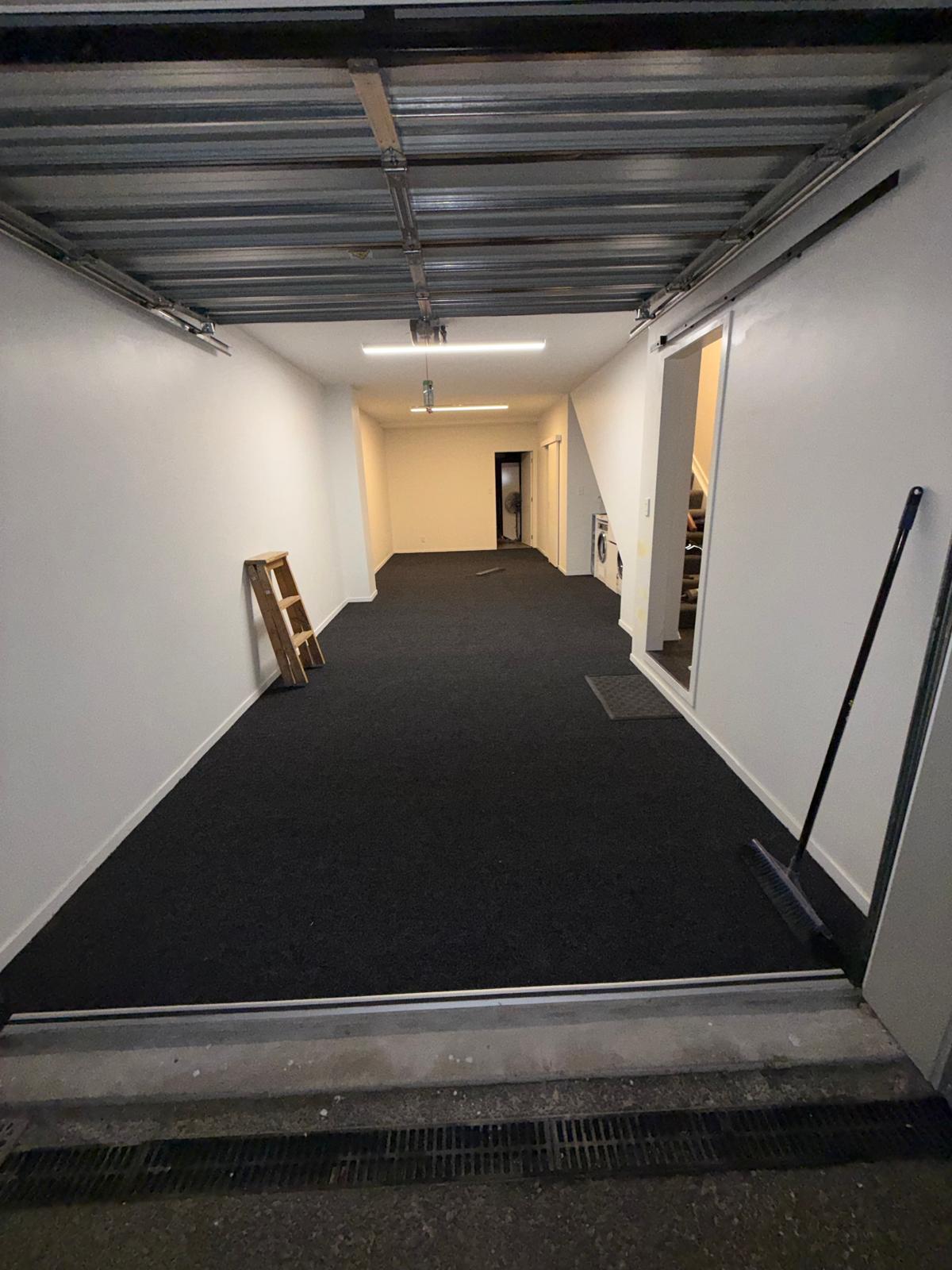Long garage and hallway freshly laid with charcoal carpet wall to wall