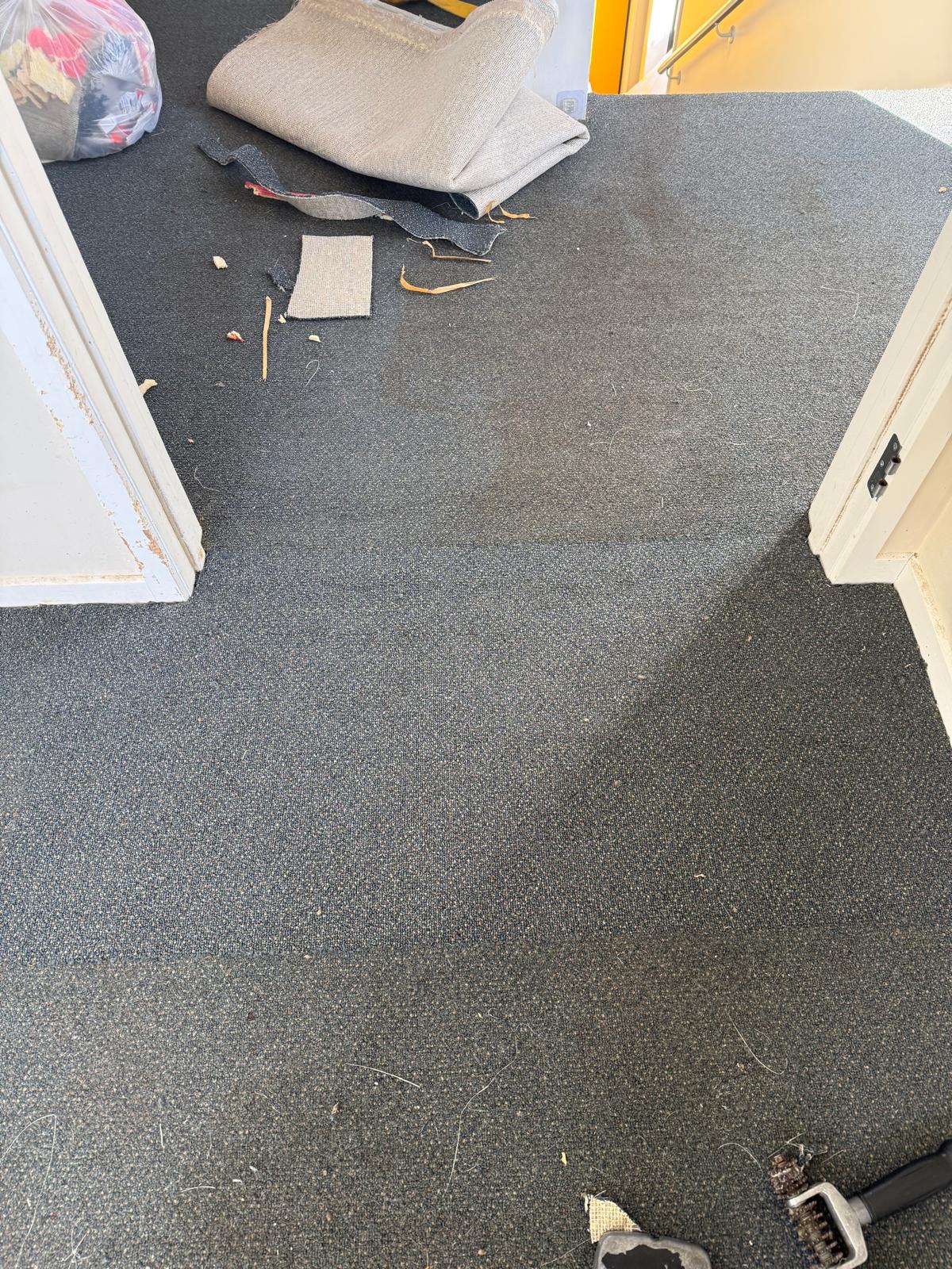 Rolled carpet and offcut materials staged on the floor ahead of installation