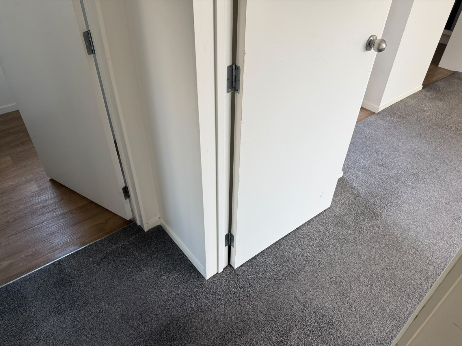 Finished grey carpet meeting neatly at a bifold closet door corner